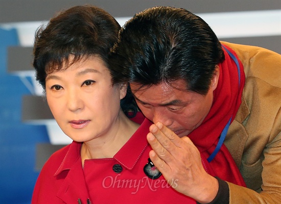 2012년 12월 16일 제18대 대통령선거 후보자 3차 토론회에 참석한 박근혜 새누리당 대선후보가  토론 시작을 기다리며 앵커 출신인 정성근 공보위원과 귀엣말을 나누고 있다.