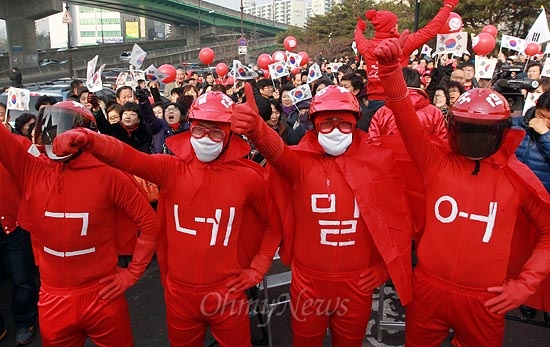 제18대 대통령 선거를 이틀 앞둔 17일 오전 충남 천안 서북구 이마트 앞에서 열린 박근혜 새누리당 대선후보 유세에서 대학생들이 빨간 쫄쫄이 복장으로 가슴에 '그네밀어'라는 글을 적고 박 후보를 응원하고 있다.