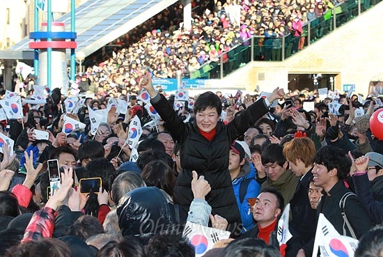제18대 대통령 선거를 하루 앞둔 박근혜 새누리당 대선후보가 18일 오후 부산 동구 부산역광장 유세에서 환호하는 유권자와 지지자들에게 손을 흔들며 인사하고 있다.