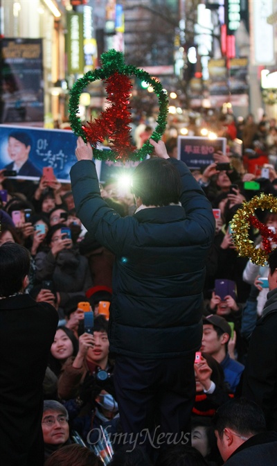 안철수 전 무소속 대선후보가 18일 오후 서울 중구 명동에서 투표 참여 독려 번개모임을 열고 시민들을 향해 투표도장 모양의 장식물을 들어보이고 있다.