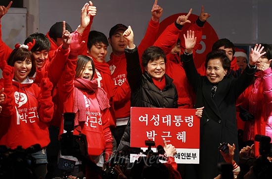 제18대 대통령 선거를 하루 앞둔 박근혜 새누리당 대선후보가 18일 오후 서울 종로구 광화문광장 유세에서 가수 이미자와 청년유세지원단 '빨간운동화' 단원들과 함께 '젊은 그대' 노래를 부르며 손을 들어보이고 있다.