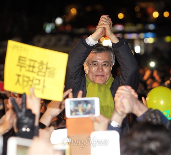 문재인 민주통합당 대선후보가 제18대 대통령선거일을 하루 앞둔 18일 저녁 부산역 광장에서 마지막 유세를 펼치며 환호하는 지지자들을 향해 필승을 다짐하고 있다.