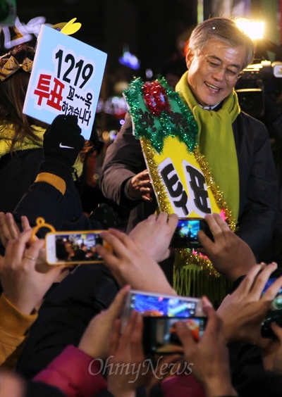 문재인 민주통합당 대선후보가 18일 밤 부산 중구 광복동에서 열린 마지막 공식유세에서 환호하는 시민들과 악수하고 있다.