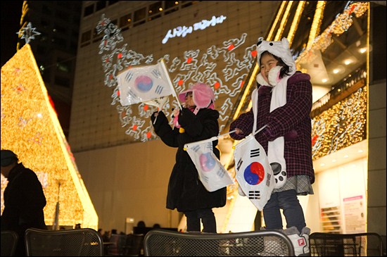 18대 대선 마지막 선거운동일인 18일 밤 박근혜 후보가 서울 두산타워 안에서 선거운동을 하는 동안, 박 후보 지지자의 자녀인 5세, 6세 자매가 인근 카페 테이블 위에서 "박근혜! 대통령!"을 외치고 있다. 