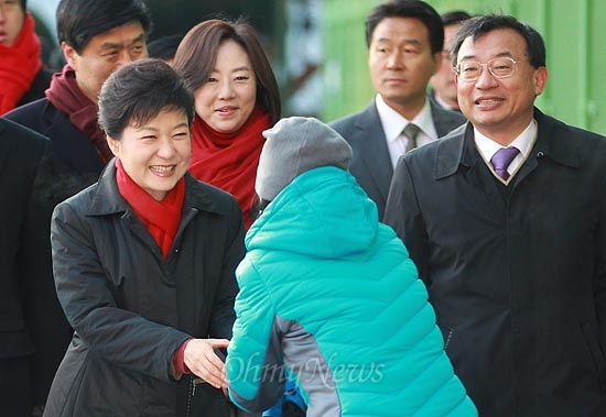 제18대 대통령선거 날인 19일 오전 서울 강남구 언주중학교에 마련된 삼성2동 제3투표소에서 박근혜 새누리당 대선후보가 투표하기 위해 이동하며 유권자들과 인사를 나누고 있다.