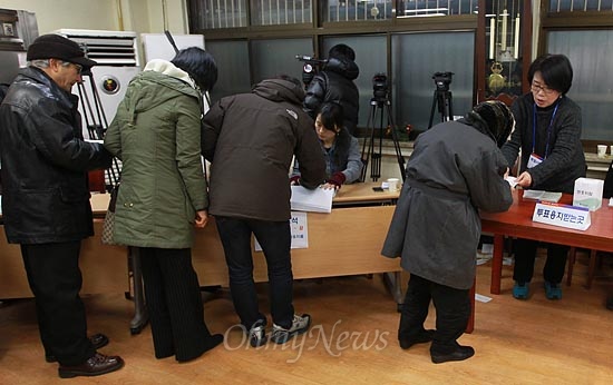 제18대 대통령선거 날인 지난 2012년 12월 19일 오전 서울 한 투표소에서 유권자들이 투표를 하려고 줄을 서서 투표용지를 받고 있다.