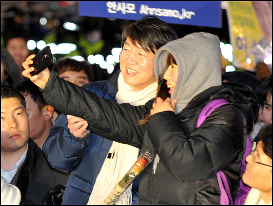 안철수 전 후보가 제18대 대통령선거를 하루 앞둔 18일 저녁 서울 강남역사거리에서 민주통합당 문재인 후보의 지원유세를 펼치고 있는 가운데 수능을 마친 고3 학생과 기념사진을 찍고 있다.