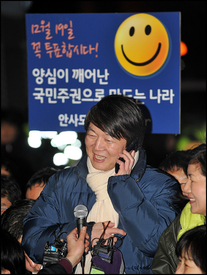 안철수 전 후보가 제18대 대통령선거를 하루 앞둔 18일 저녁 서울 강남역사거리에서 민주통합당 문재인 후보의 지원유세를 펼치고 있는 가운데 한 지지자와 직접 전화통화를 하고 있다.