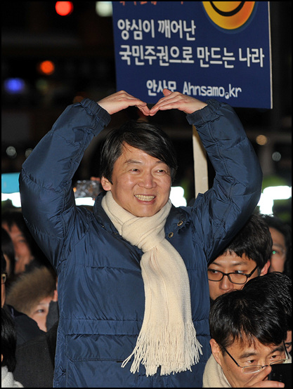안철수 전 후보가 제18대 대통령선거를 하루 앞둔 18일 저녁 서울 강남역사거리에서 민주통합당 문재인 후보의 지원유세를 펼치고 있는 가운데 시민들을 향해 하트를 만들어 보이고 있다.