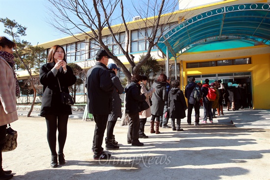 제18대 대통령선거날인 19일 오전 서울 은평구 불광초등학교에 설치된 불광1동 제3투표소에서 유권자들이 투표를 하기 위해 길게 줄을 서 있다.