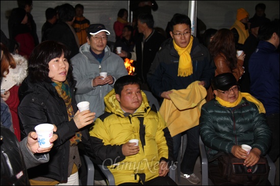 19일 저녁 경남 김해 봉하마을 방앗간 앞 마당에 모인 사람들은 제18대 대통령선거 방송3사 출구조사에서 문재인 후보가 박근혜 후보한테 지는 것으로 나오자 굳은 표정을 짓고 있다.