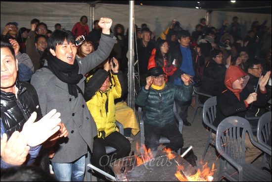 19일 저녁 경남 김해 봉하마을 방앗간 앞 마당에 모인 사람들은 제18대 대통령선거 YTN 출구조사에서 문재인 후보가 박근혜 후보한테 이기는 것으로 나오자 환호성을 지르고 있다.