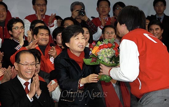 19일 실시된 제18대 대통령선거에서 당선이 확실시 되는 새누리당 박근혜 후보가 이날 밤 새누리당 당사 종합상황실을 찾아 이준석 전 비대위원으로부터 축하 꽃다발을 건네받고 있다.