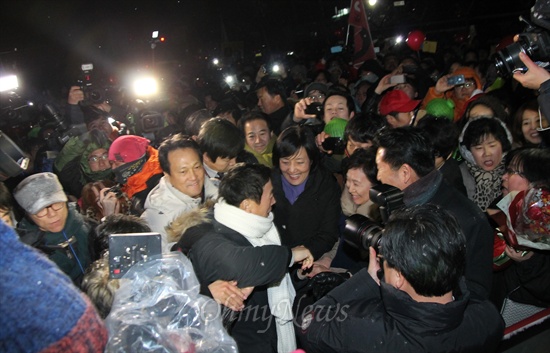 25일 자정, 홍성교도소에서 출소한 정봉주 전 의원이 환영을 나온 민주통합당 박영선, 안민석 의원들과 인사를 나누며 무대에 오르고 있다.