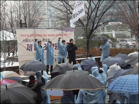  서울도시철도노조 정주남 위원장과 김태훈(승무본부장), 이재문(기술본부장), 전태종(차량본부장), 황우진(역무본부장)이 도시철도본관앞 마당에서 조합원 300명이 참석한 가운데, "현장인력 충원하라"고 구호를 외치고 있다.
