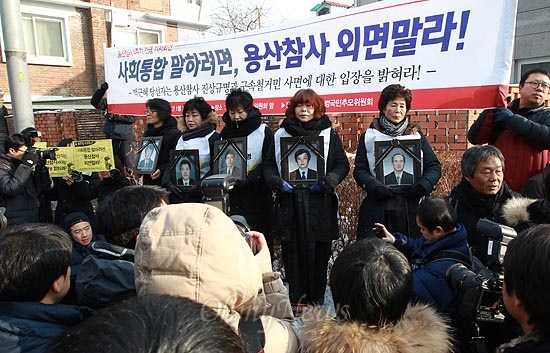 용산참사 유가족인 전재숙, 유영숙, 권명숙, 김영덕씨(오른쪽부터)가 7일 오전 서울 종로구 삼청동 한국금융연수원 내에 마련된 대통령직 인수위원회 앞에서 고인들의 영정사진과 검은 상복을 입고 용산참사 진상규명과 구속철거민 사면에 대한 박근혜 당선인의 입장을 밝힐 것을 요구하고 있다.