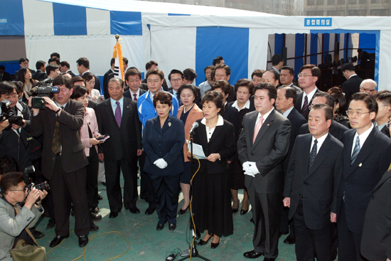 2004년 3월 24일 당시 한나라당의 박근혜 대표와 당직자들이 여의도 천막당사 입주식에서 국민에게 드리는 글을 낭독하고 있다.