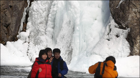 9일 경남 함양군 안의면 상원리 높이 15m 용추폭포가 맹추위에 꽁꽁 얼어붙어 장관을 이루자 한 관광객이 사진촬영을 하고 있다.
