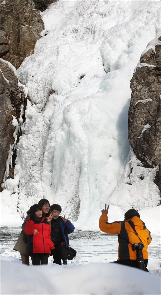 9일 경남 함양군 안의면 상원리 높이 15m 용추폭포가 맹추위에 꽁꽁 얼어붙어 장관을 이루자 한 관광객이 사진촬영을 하고 있다.

