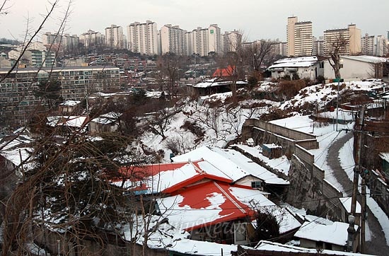 8일 오후 서울 성북구 정릉3동 정릉생명평화마을 낮은 지붕 위에 하얀 눈이 쌓여있다. 오래된 마을에 도시가스가 들어오지 않아 연탄으로 겨울을 나는 집도 있지만 마을주민들과 젊은 예술가들은 마을의 자립 순환 경제를 만들기 위해 게스트하우스와 공동텃밭, 공동작업장을 운영하며 마을커뮤니티를 형성하고 있다.
뒤로 높게 솟은 아파트 단지가 병풍처럼 늘어서져 있지만 정릉평화마을은 따뜻한 정이 느껴지는 마을이다.