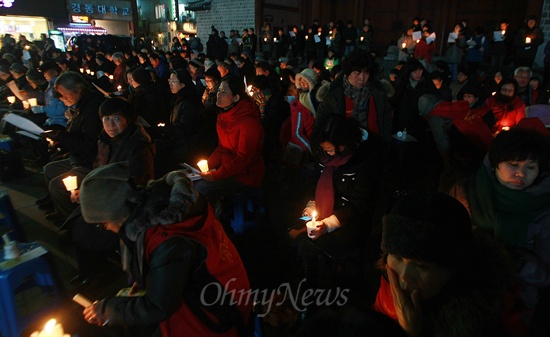 지난 14일 오후 서울 대한문 앞에서 열린 '용산참사 4주기 추모미사'에 참가한 시민들이 촛불을 들고 있다.