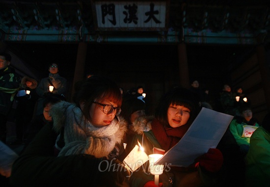 14일 오후 서울 대한문 앞에서 열린 '용산참사 4주기 추모미사'에 참가한 시민들이 촛불을 들고 있다.