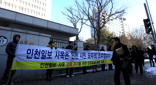 9일 인천 법조타운을 지나가는 시민이 <인천일보> 사옥 매각 반대를 주장하는 현수막을 보고 있다. 