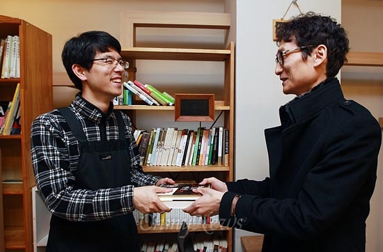 15일 오후 서울 서초구 서초동 남부터미널 인근에 위치한 협동조합 카페 '카페 오공'에서 재능나눔에 참가한 홍용호씨가 카페 매니저 조정훈씨에게 책을 기증하고 있다.
