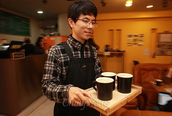 15일 오후 서울 서초구 서초동 남부터미널 인근에 위치한 협동조합 카페 '카페 오공'에서 카페 매니저 조정훈씨가 손님이 주문한 음료를 나르고 있다.