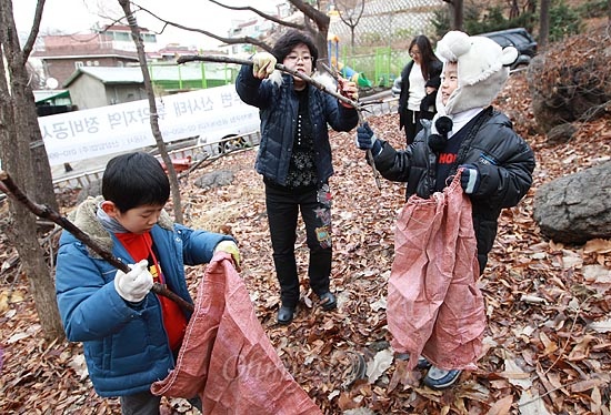 22일 오후 서울 동작구 상도동 국사봉 등산로에서 '성대골 마을학교' 아이들이 마을학교의 화목난로에 땔 나뭇가지를 찾아 포대 자루에 넣고 있다.