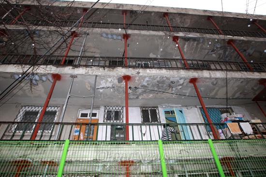 붕괴우려 수준인 'E등급'을 받은 서울 성북구 정릉스카이아파트 3동에 붕괴를 막기 위해 빨간 쇠기둥이 촘촘하게 층층이 박혀 있다. 이 건물에는 아직도 주민들이 살고 있다.