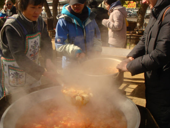 홈리스들에게 점심으로 주기해서 끓인 김치찌개를 큰 냄비에 옮겨 담고 있습니다. 