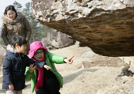 양해숙 문화유산해설사가 화순 고인돌 유적지에서 부모와 함께 온 한 어린이에게 고인돌에 대해 설명해 주고 있다.