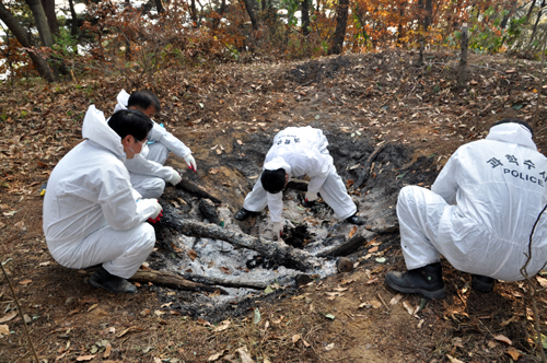 몇년 전, 청주 우암산에서 불교화장식인 다비식을 치르며 기름으로 몸에 불을 지르고 사망한 사람의 DNA를 체취하고 있는 과학수사대 요원들.(사진제공 = 충북경찰청)