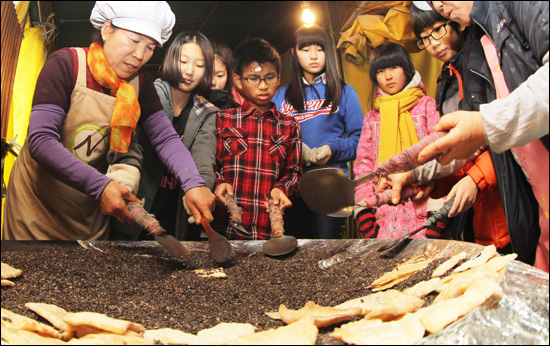  설 명절을 나흘 앞둔 6일 경남 함양군 지곡면 개평전통한옥마을 찾은 어린이들이 자갈에서 굽어내는 전통한과 만들기 체험을 해 보고 있다.
