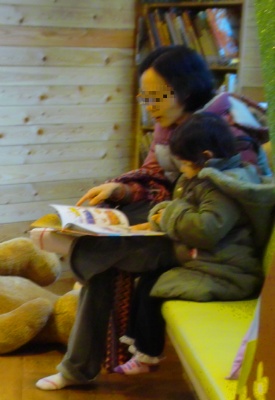 '어린이실'에서 한 어린이가 엄마와 함께 책을 읽고 있다.