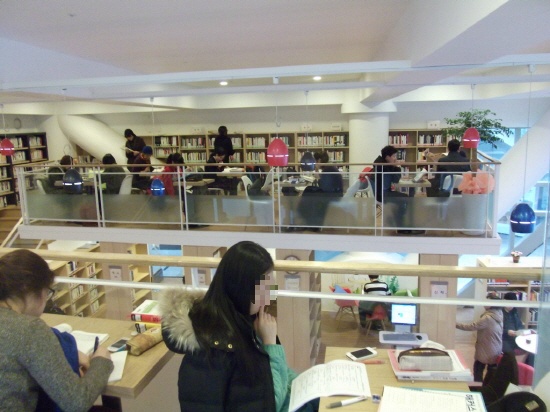 용꿈꾸는 작은 도서관에서 독서에 열중하고 있는 주민들. 복층구조로 북카페 형식으로 되어 있는 도서관은 아기 수유실까지 설치되어 있다.