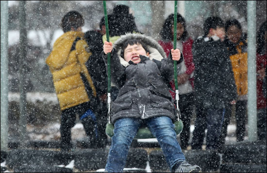  함양초등학교 놀이터에서 어린이들이 눈이 내리는 속에 그네를 타며 즐거워 하고 있다.
