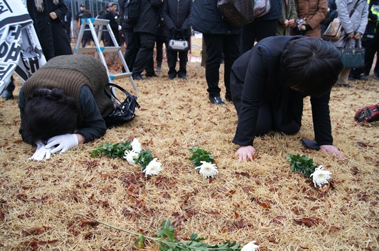 대구 지하철 참사 유족들이 2013년 2월 18일 팔공산 시민안전테마파크에 있는 위령탑 앞 잔디밭에서 헌화한 뒤 엎드려 흐느끼고 있다. 2003년 2월 18일 대구 중구 남일동 중앙로역에서 발생한 방화로 인한 참사로 192명이 사망했다.