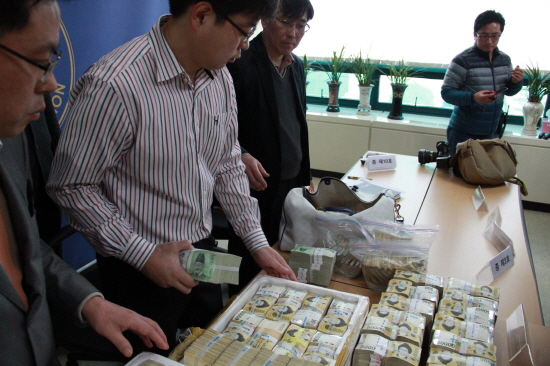아산경찰서는 공금횡령 피의자 윤씨가 아이스박스에 담아 텃밭과 빌라 등에 숨겼던 돈을 꺼내 기자들에게 공개했다. 