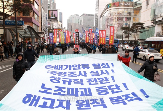 '5대 긴급 노동현안이 적힌 대형현수막을 앞세운 전국노동자대회 참석자들이 명동입구에서 행진을 벌이고 있다.