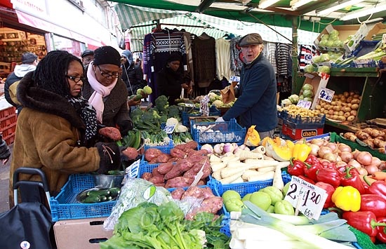 14일 오전 런던 브릭스톤(Brixton) 역 인근 브릭스톤 시장에서 손님이 가판대에 가지런히 놓여있는 싱싱한 채소를 구입하고 있다.