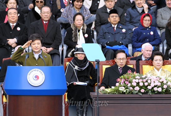 박근혜 대통령이 2013년 2월 25일 오전 서울 여의도 국회의사당 앞 광장에서 열린 제18대 대통령 취임식에서 육·해·공 3군 의장대와 군악대의 사열을 받으며 거수경례를 하고 있다. 
