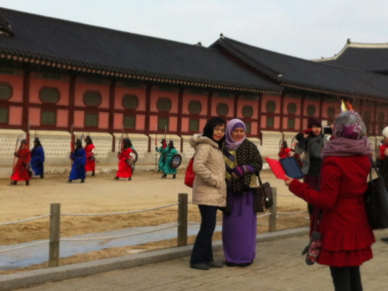 외국인 관광객들이 한국의 대표적인 관광지인 경복궁에서 기념사진을 찍고 있다.