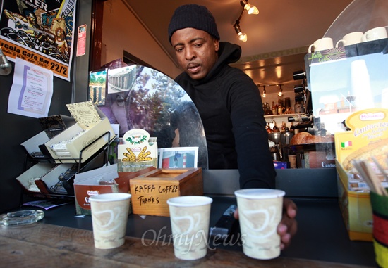 18일 오전 영국 런던 해크니(Hackney) 달스턴 킹스랜드(Dalston Kingsland)역 인근 질레트 스퀘어(Gillett Square) 광장에서 카페를 운영하고 있는 마르코스(Marcos)가 커피를 손님에게 건네주고 있다.