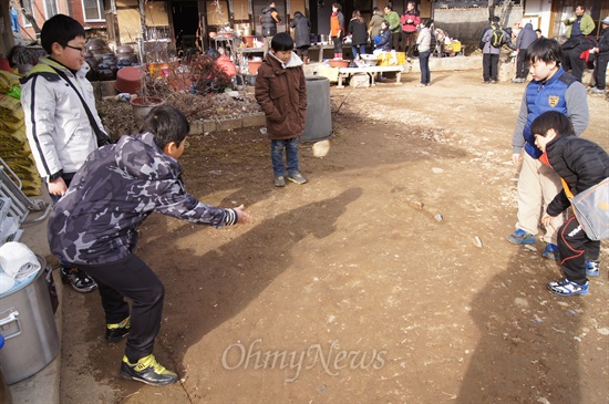 삼평리에서 열린 송전탑 건설을 반대하는 할머니들을 위한 콘서트에 찾아온 아이들이 마당 한구석에서 비석깨기 놀이를 하고 있다.