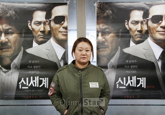  영화<신세계>의 박민정 프로듀서가 25일 오후 서울 신사동에서 오마이스타와 인터뷰에 앞서 영화포스터를 배경으로 포즈를 취하고 있다.