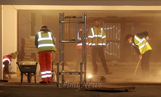 14일 오후 영국 브릭스톤(Brixton) 주택가 인근 한 주차장에서 리메이커리(Remakery) 소속 자원 봉사자들이 주민들의 작업 공간을 만들기 위해 청소를 하고 있다.