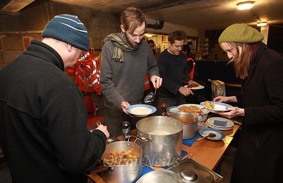 14일 오후 영국 브릭스톤(Brixton) 주택가 인근 한 주차장에서 리메이커리(Remakery) 소속 자원 봉사자들이 작업을 마친 뒤 다 함께 저녁 식사를 하고 있다.