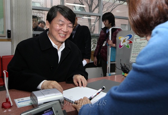 안철수 전 서울대 교수가 12일 오후 서울 노원구 상계1동 주민센터에서 전입신고를 하던 도중 주민센터 직원으로부터 사인을 요청받고 있다.